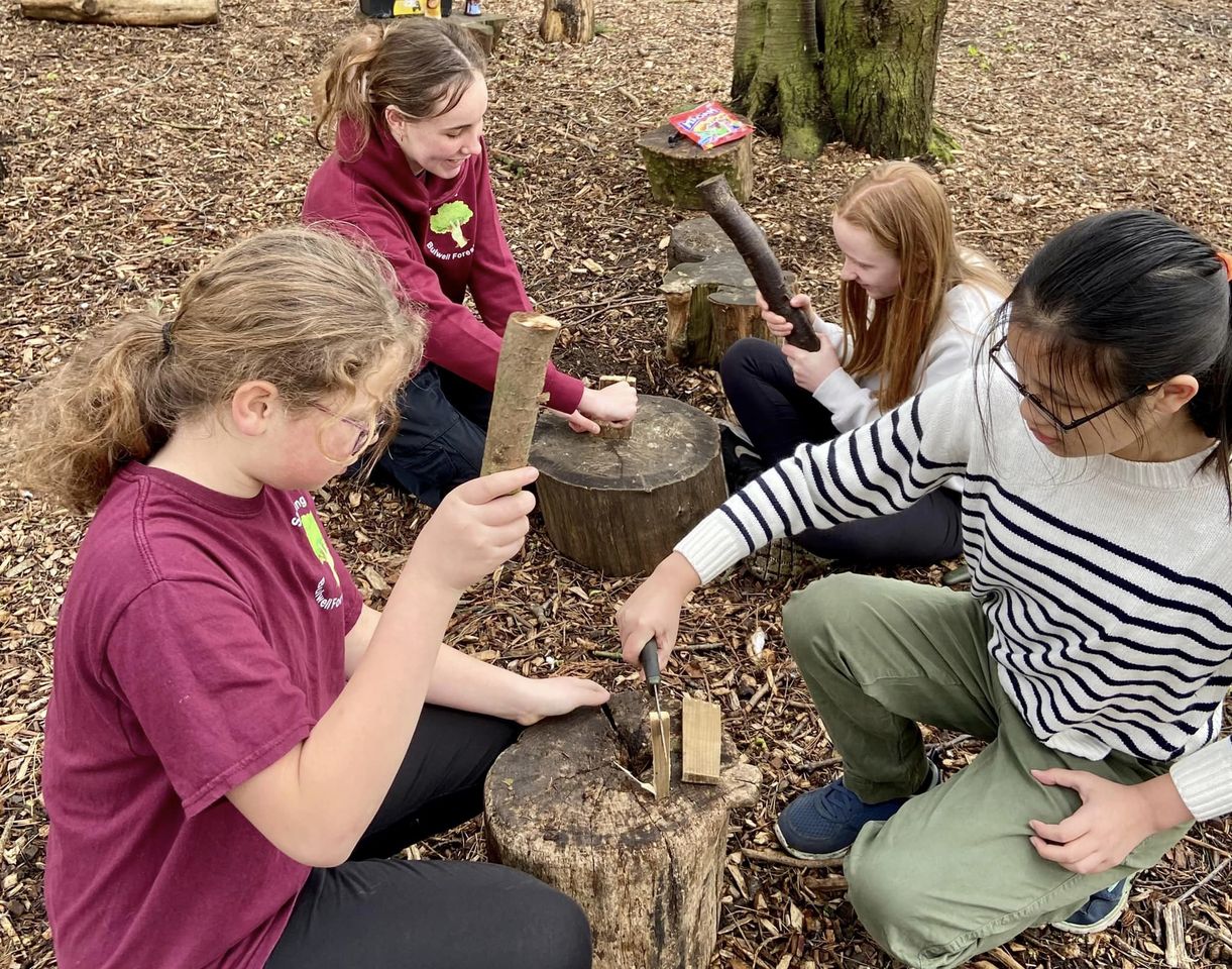 Group of four girls chopping wood