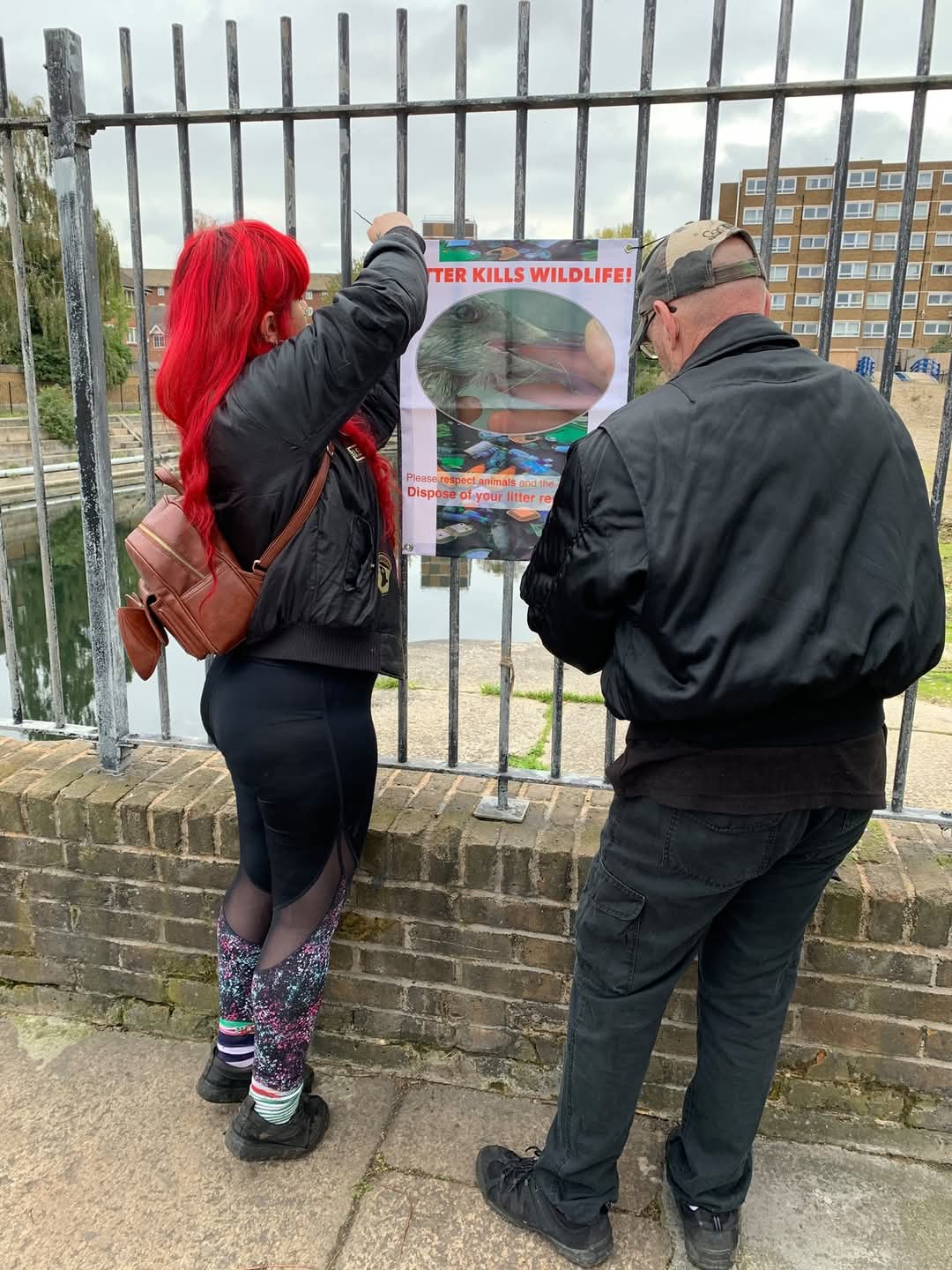 Volunteers putting up a poster about the danger posed by litter to wildlife