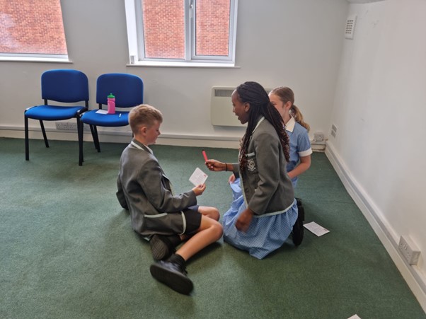 Three students discussing drug issues in classroom