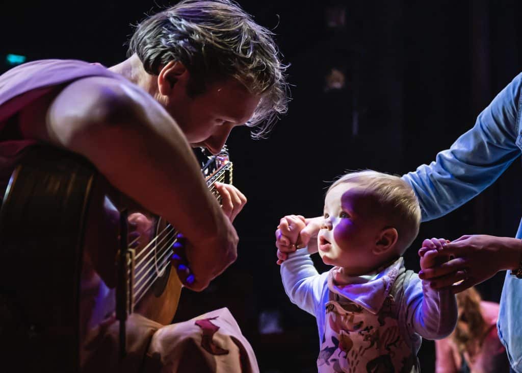 Man playing a guitar for a child