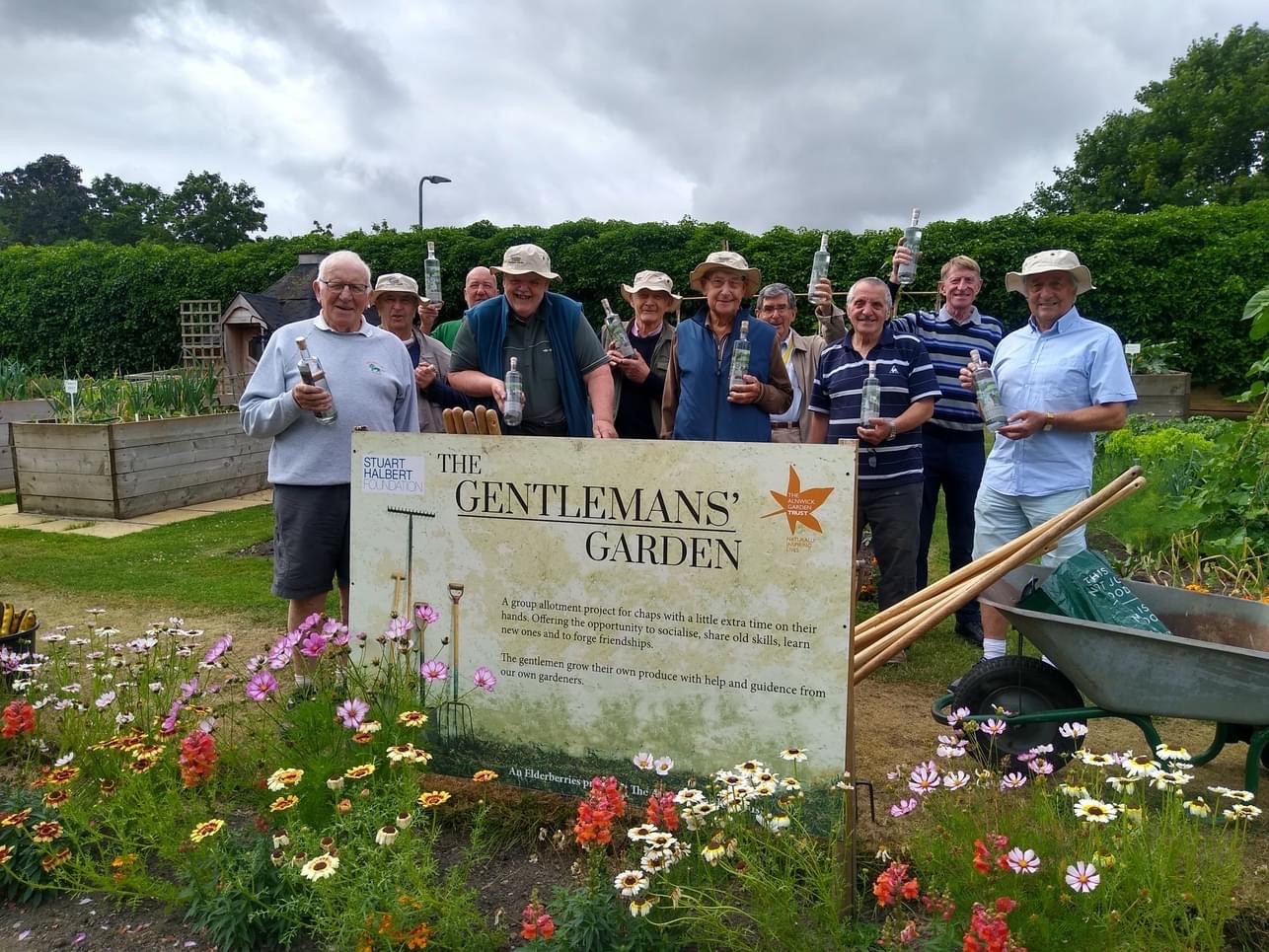 a group of gentlemen infront of a sign that says gentlemen gardeners