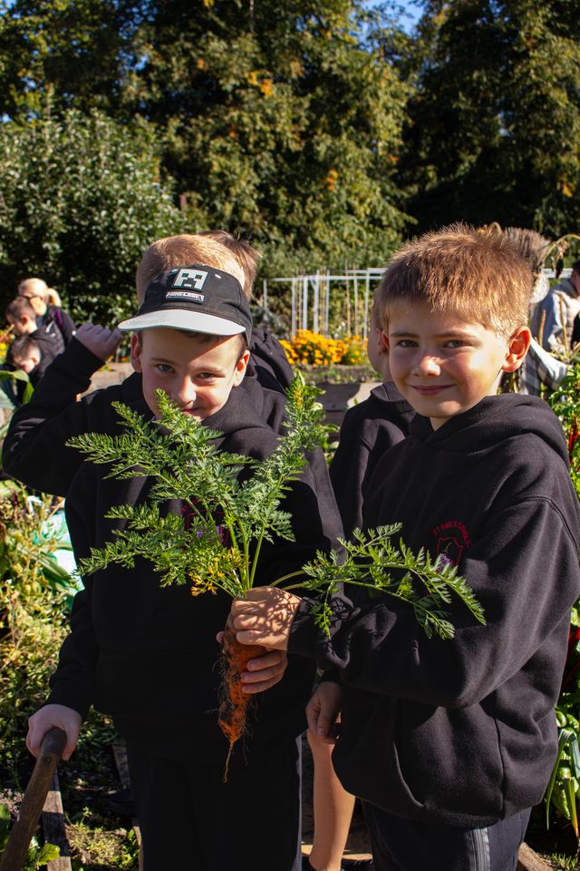 Children holding plants in a garden