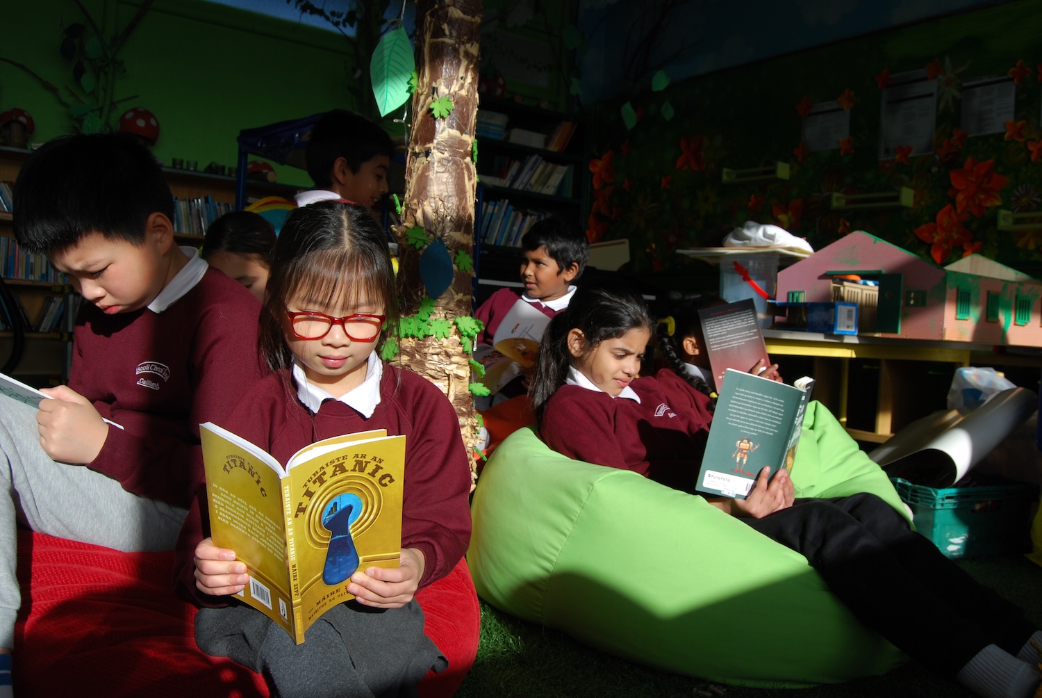 a group of school children reading in the sunlight